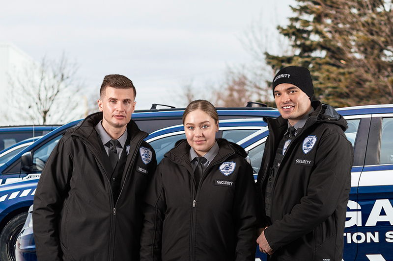 Three legacy guards standing near security cars